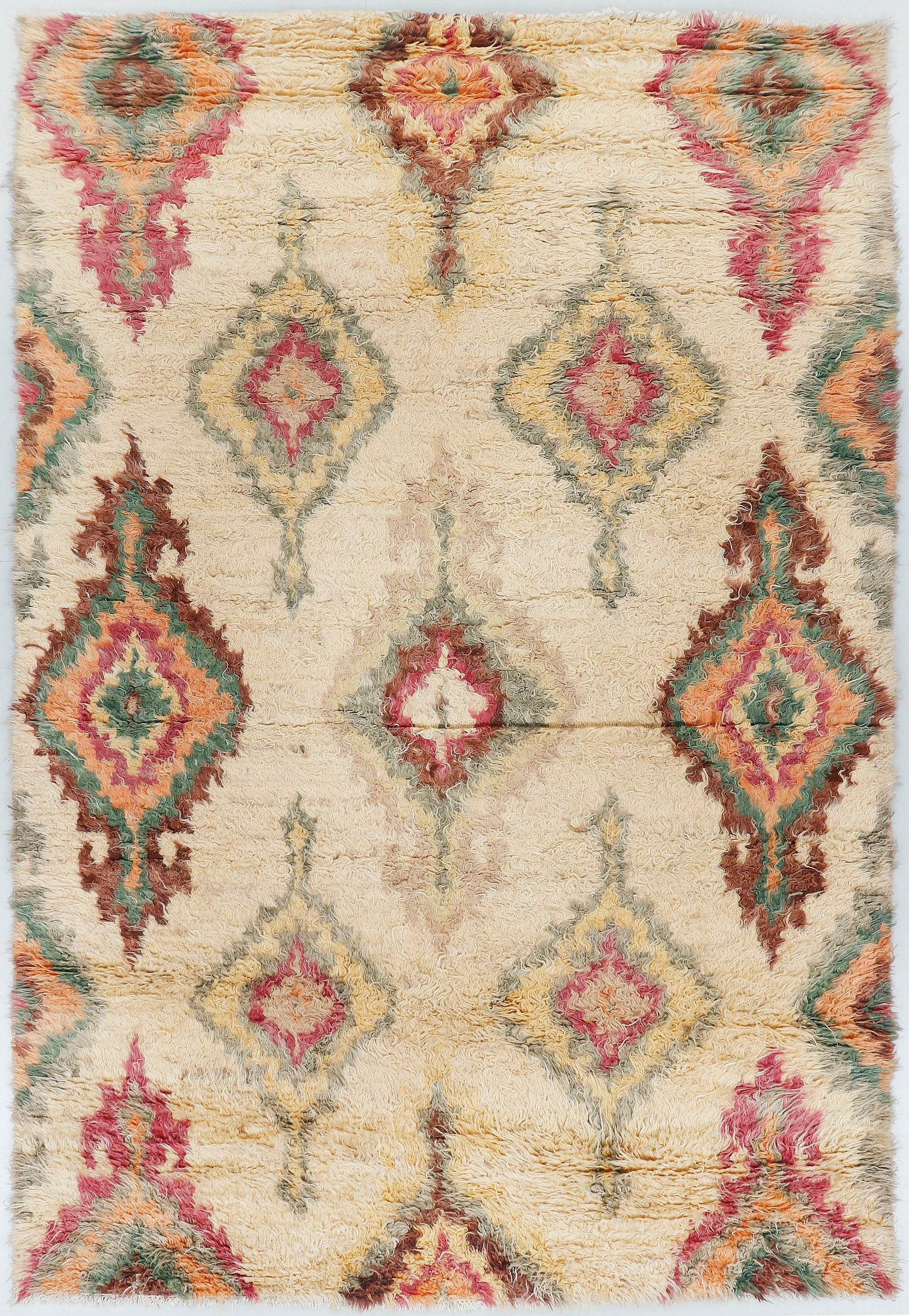 A full view of a hand-knotted, high-pile Moroccan style rug featuring a natural cream wool base with large, softly blended diamond motifs in muted rose, sage green, and golden yellow