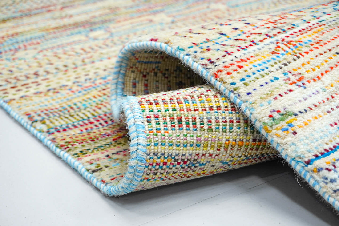 Close-up of the plush Alabaster wool pile and the vibrant multi-tonal heritage motifs of the Alabaster Rasm rug.
