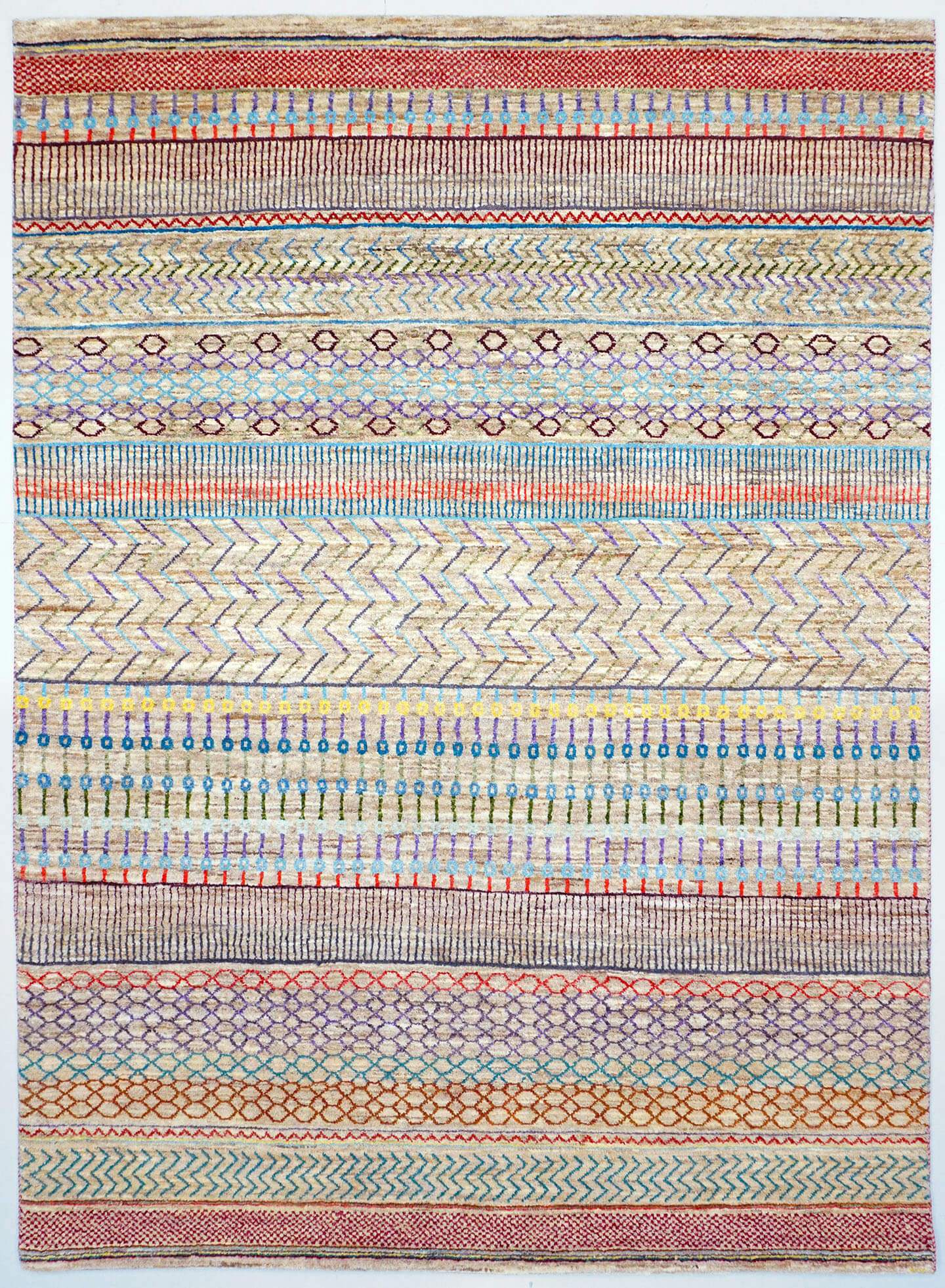 Full view of a natural white hand-knotted Aatish Gabbeh rug featuring rhythmic tiers of multi-colored Silsila motifs
