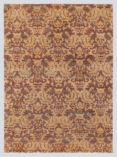 A full view of a modern transitional hand-knotted rug from the Nomad Series, featuring a repeating classical palmette pattern rendered in warm, tie-dyed wool over an amber-sand foundation.