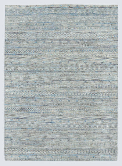 A full view of a sophisticated silver-grey hand-knotted Gabbeh rug from the Aatish collection, featuring horizontal bands of tie-dyed tribal motifs over a textured, natural wool foundation.
