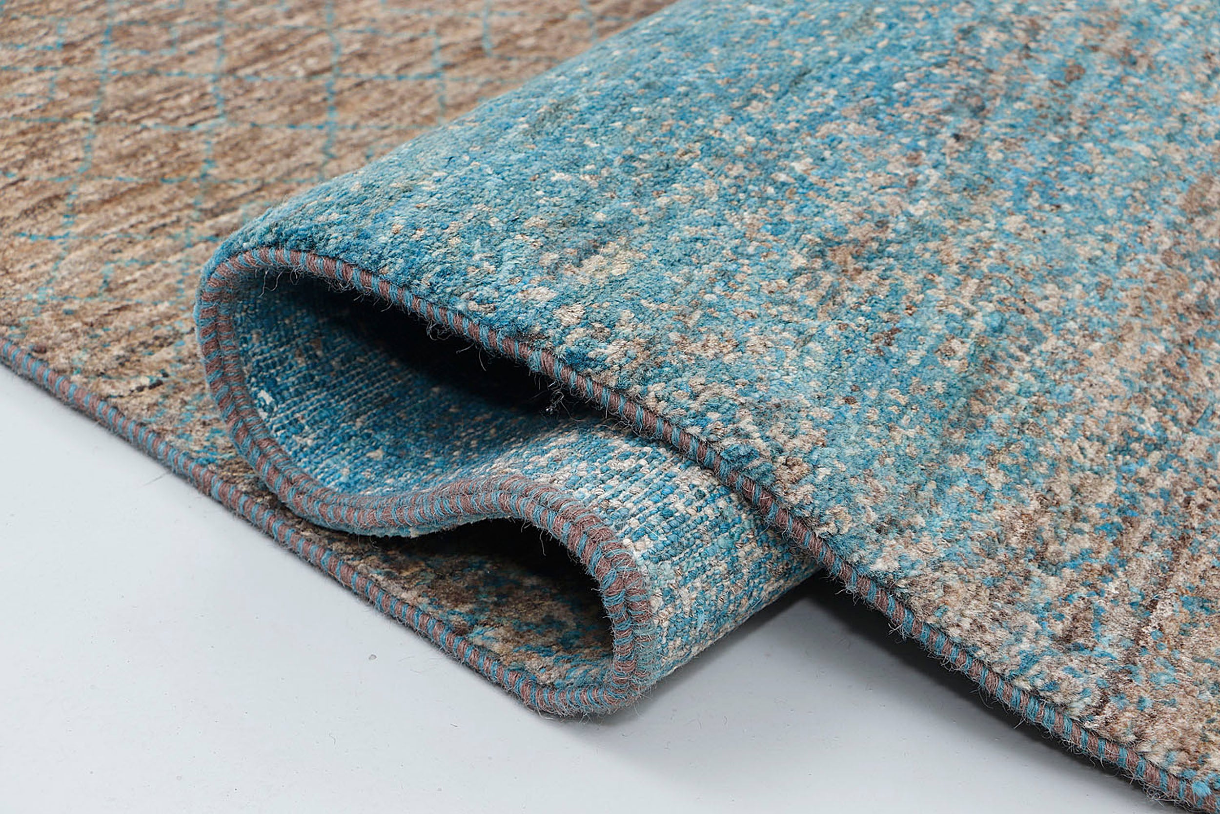 A close-up highlighting the double-knot density and the raw, variegated texture of natural Highland wool contrasted with deep blue beryl dyes.