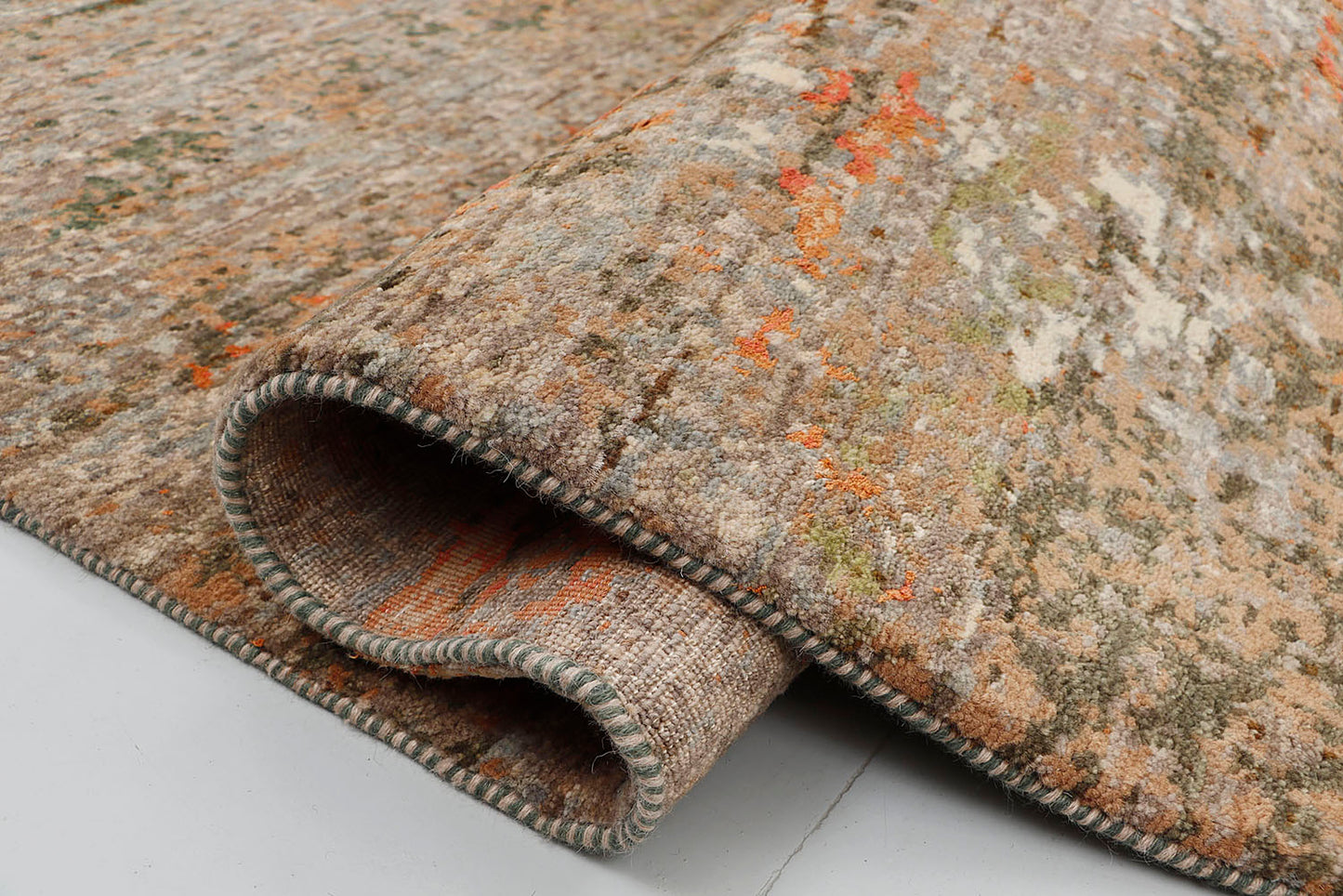 A close-up of a crisp, medium-pile hand-knotted rug highlighting the rich textural contrast and subtle metallic sheen between the pure wool and hybrid silk yarns in an abstract, scraped-paint design.