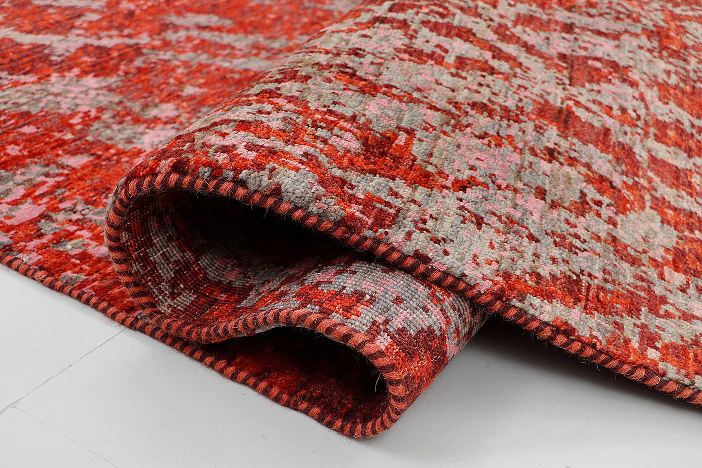 A close-up of a crisp, medium-pile wool rug highlighting the dense, tactile contrast between the vibrant red and cool silver-grey yarns in a fractured, painterly effect.