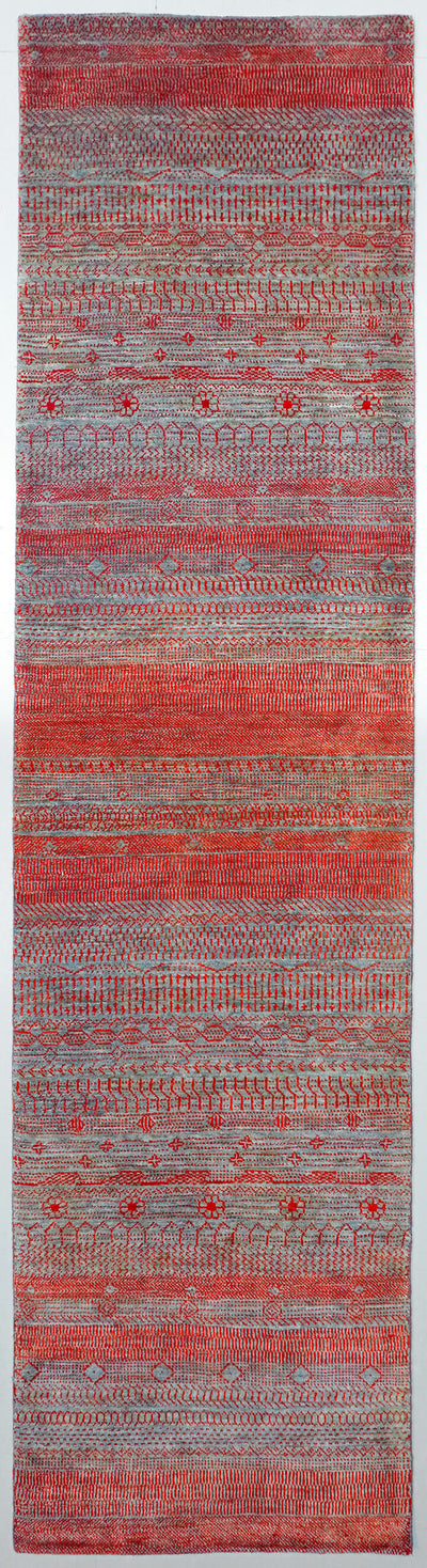 Full view of a Graphite grey hand-knotted Aatish rug featuring vibrating red and orange Pulse motifs.
