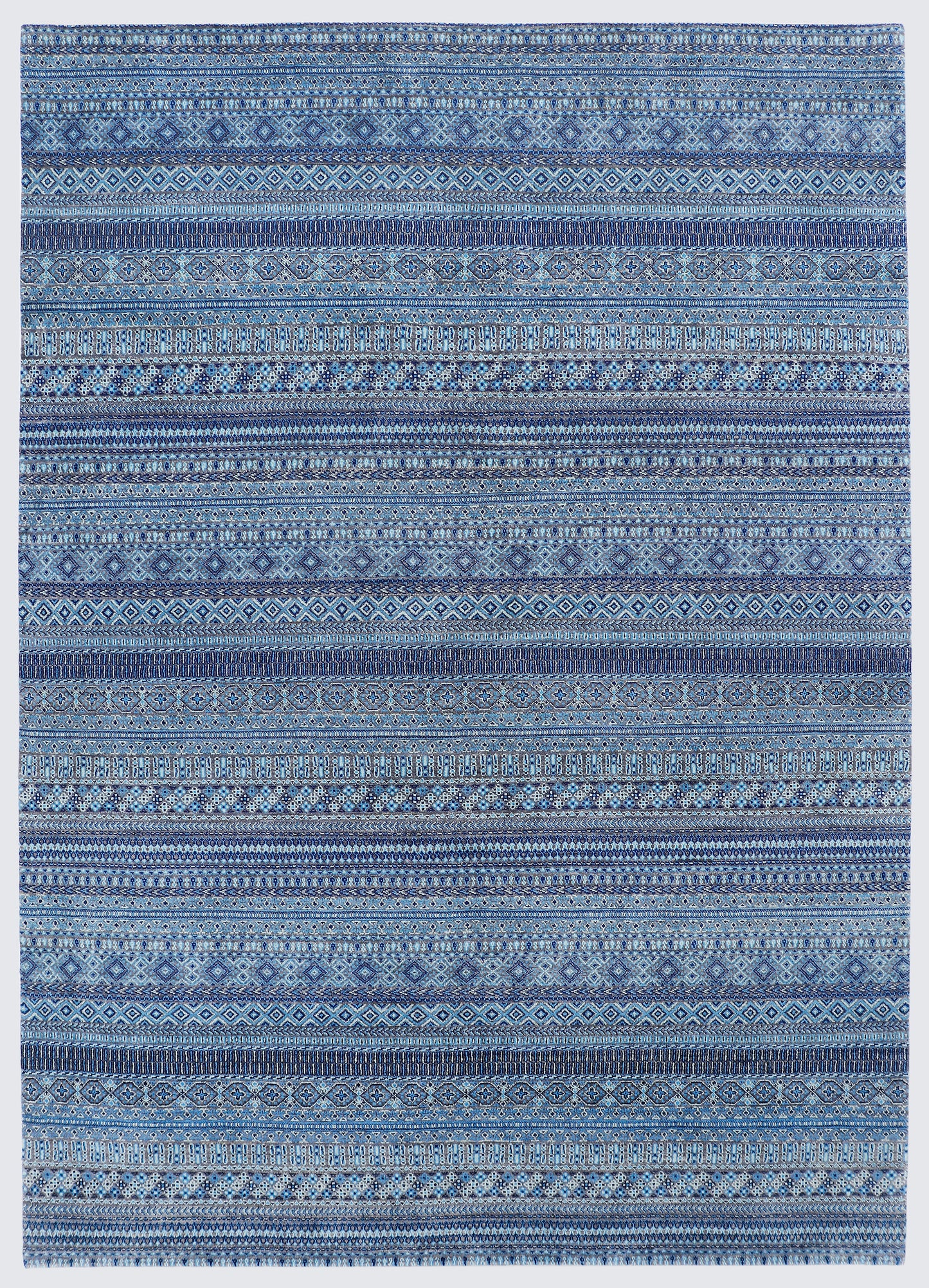A full view of a hand-knotted wool rug featuring dense horizontal bands of miniature tribal motifs in a calming monochromatic palette of indigo, steel blue, and soft azure.