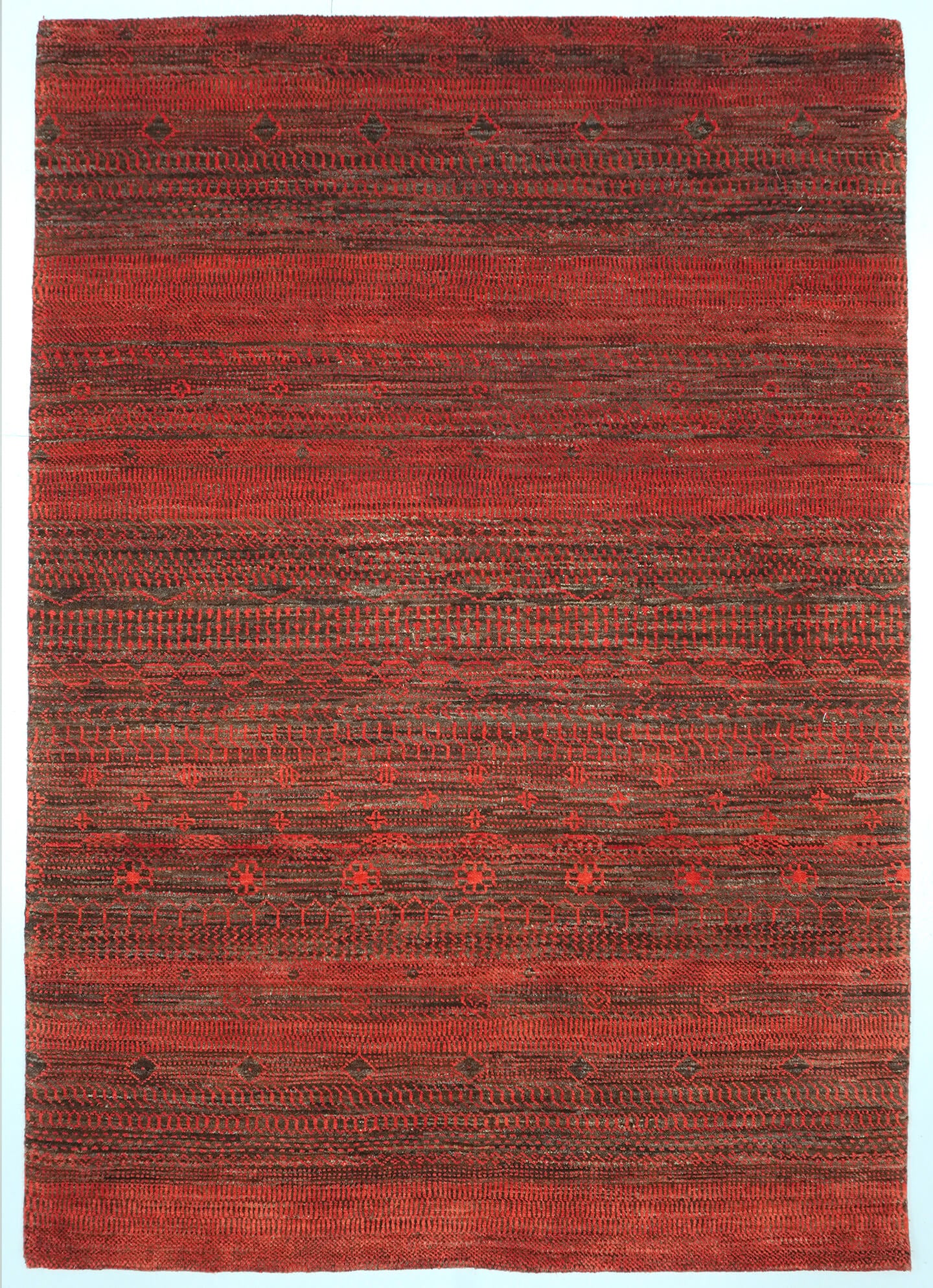 Full view of a natural brown and Madder orange hand-knotted Aatish rug featuring rhythmic Nazar motifs