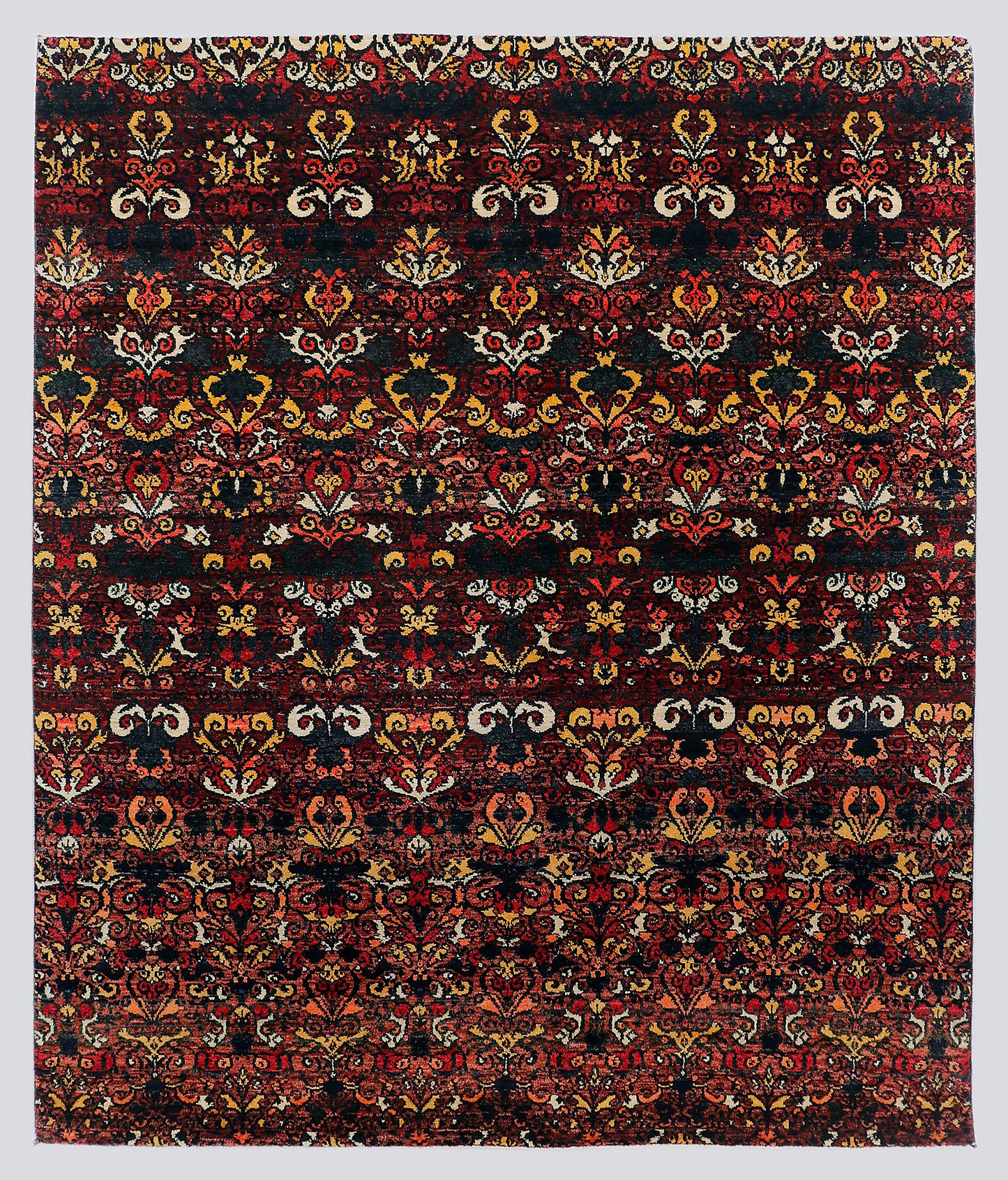 A full view of a dramatic, premium hand-knotted rug featuring repeating classical floral motifs in vivid garnet red and saffron gold against a deep midnight black foundation.