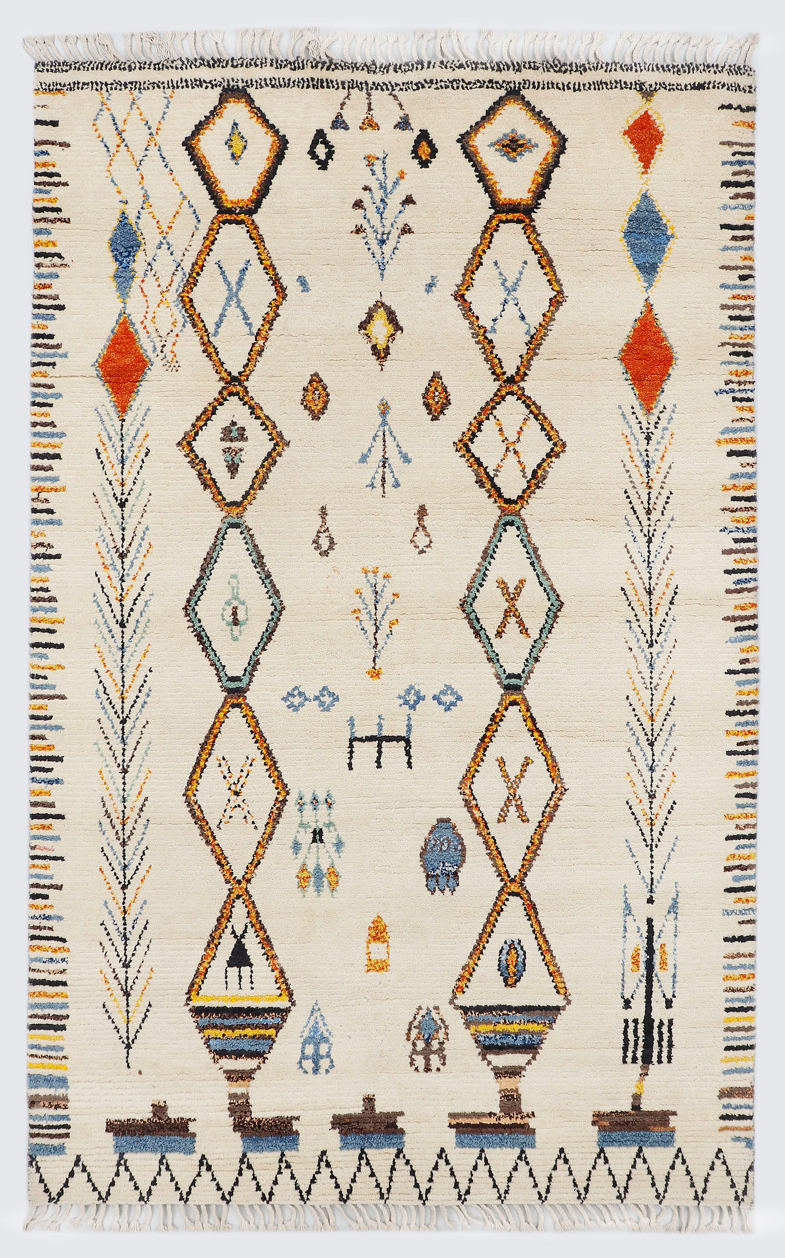 A full view of a hand-knotted, high-pile Moroccan-style rug on a natural cream background, featuring vertical stacks of diamond medallions, scattered tribal motifs, and a colorful, horizontally striped border along the sides.