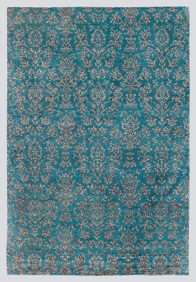 A full view of a vibrant, hand-knotted transitional rug from the Nomad Series, featuring a repeating classical trellis pattern rendered in tie-dyed wool over a vivid peacock-blue foundation.