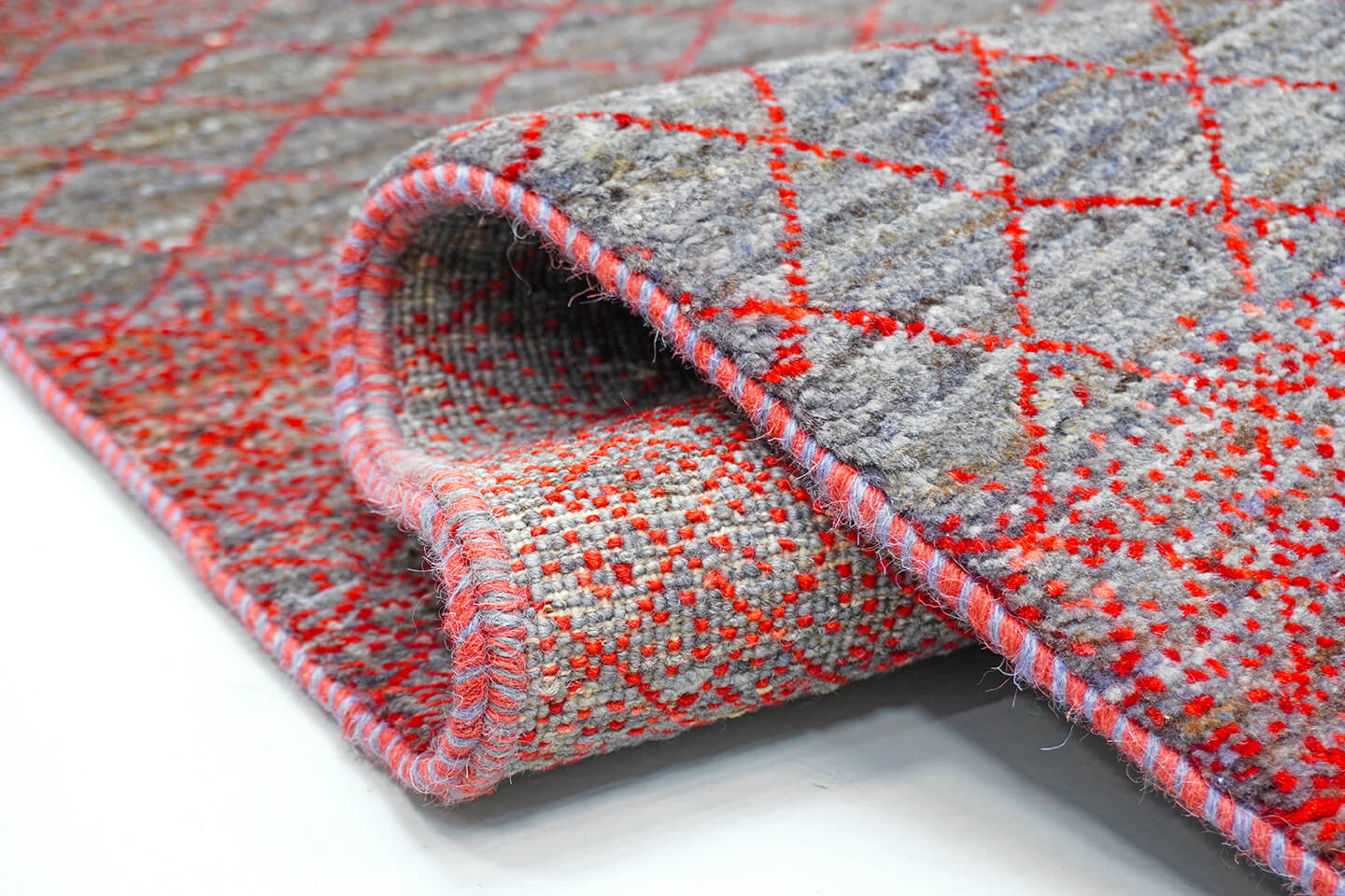 Close-up of the plush pewter wool pile and detailed crimson heritage grid levels.