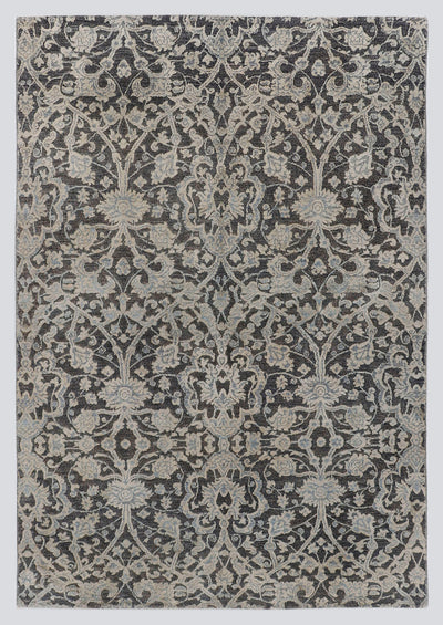 A full view of a luxury hand-knotted rug from the Nomad Series, featuring a high-low pile design with raised, silvery-ivory floral vines stretching over a deep charcoal background.
