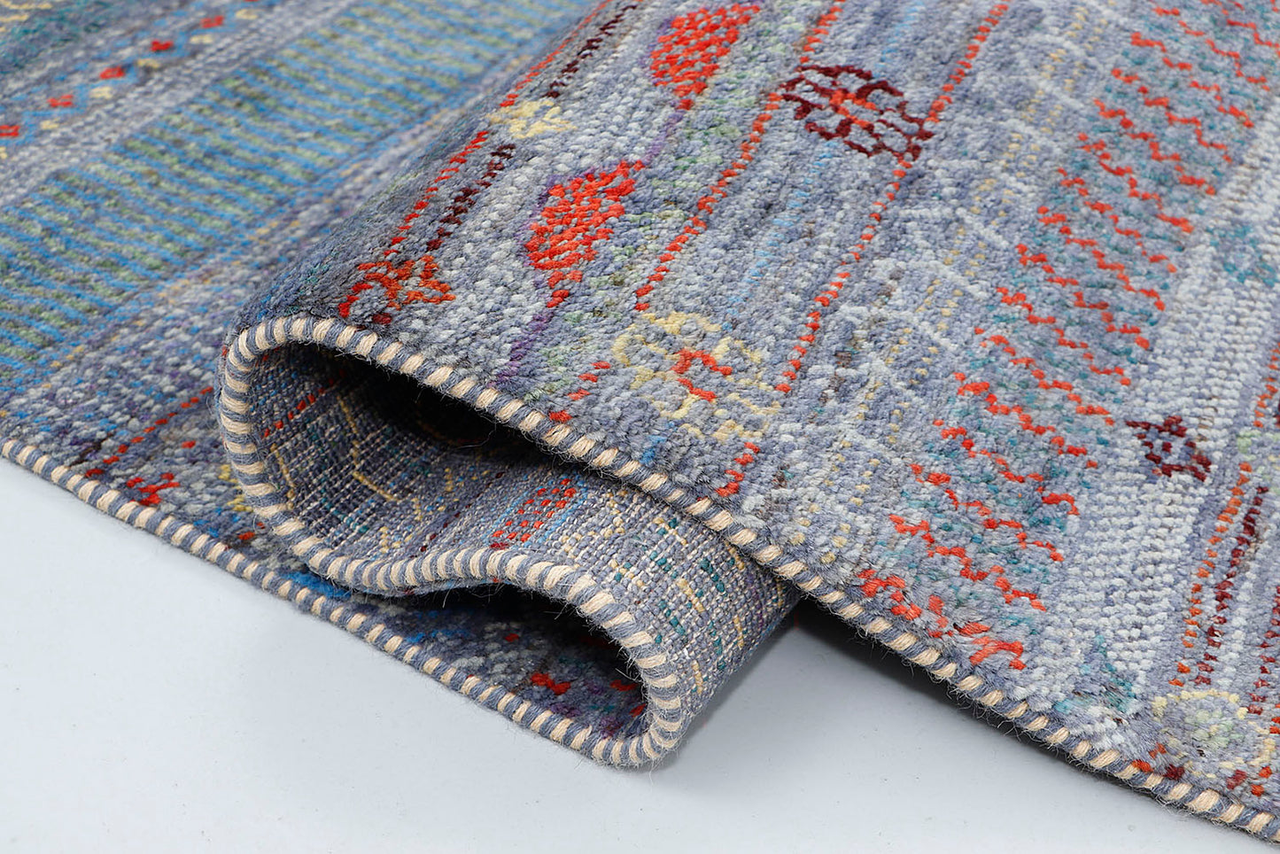 A close-up of a crisp, medium-pile wool rug highlighting intricately woven horizontal stripes filled with tiny geometric diamond patterns on a silver-grey base.