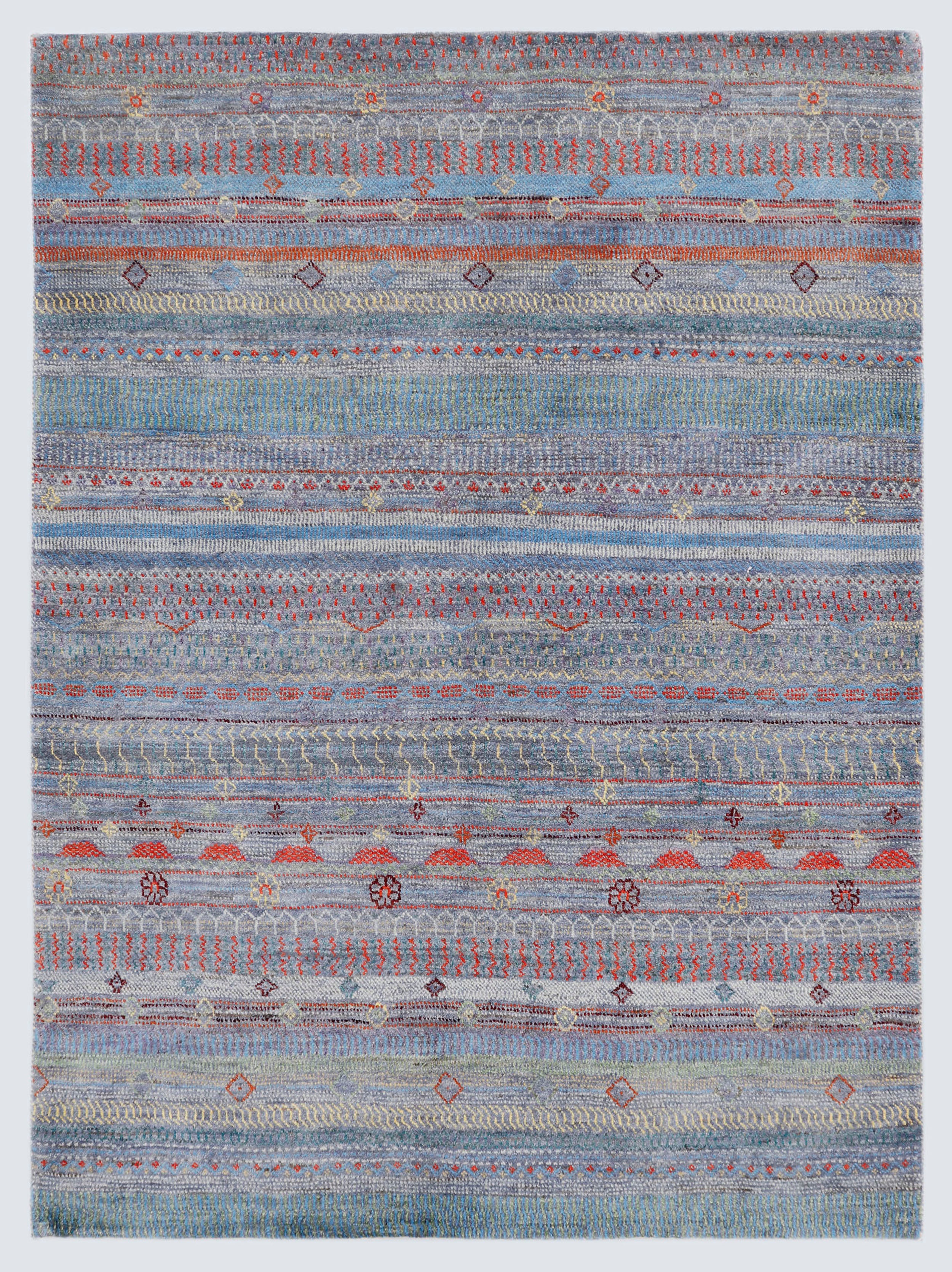 A full view of a hand-knotted wool rug featuring dense horizontal bands of miniature tribal motifs in terracotta and olive against a silver-grey foundation.