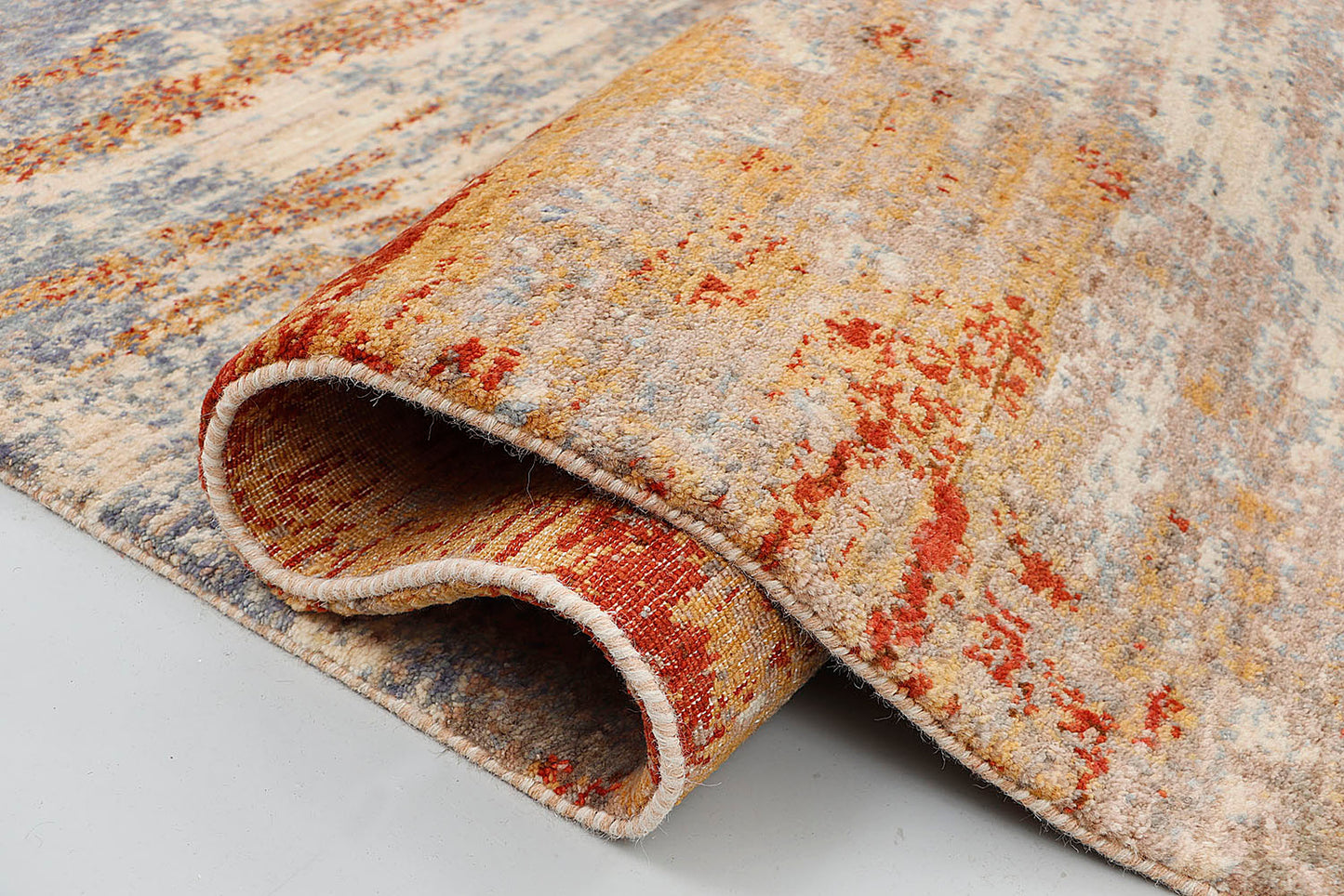 A close-up of a crisp, medium-pile hand-knotted wool rug highlighting the dense, tactile contrast between the slate blue, sienna, and cream yarns in a purely abstract, scraped-paint effect.