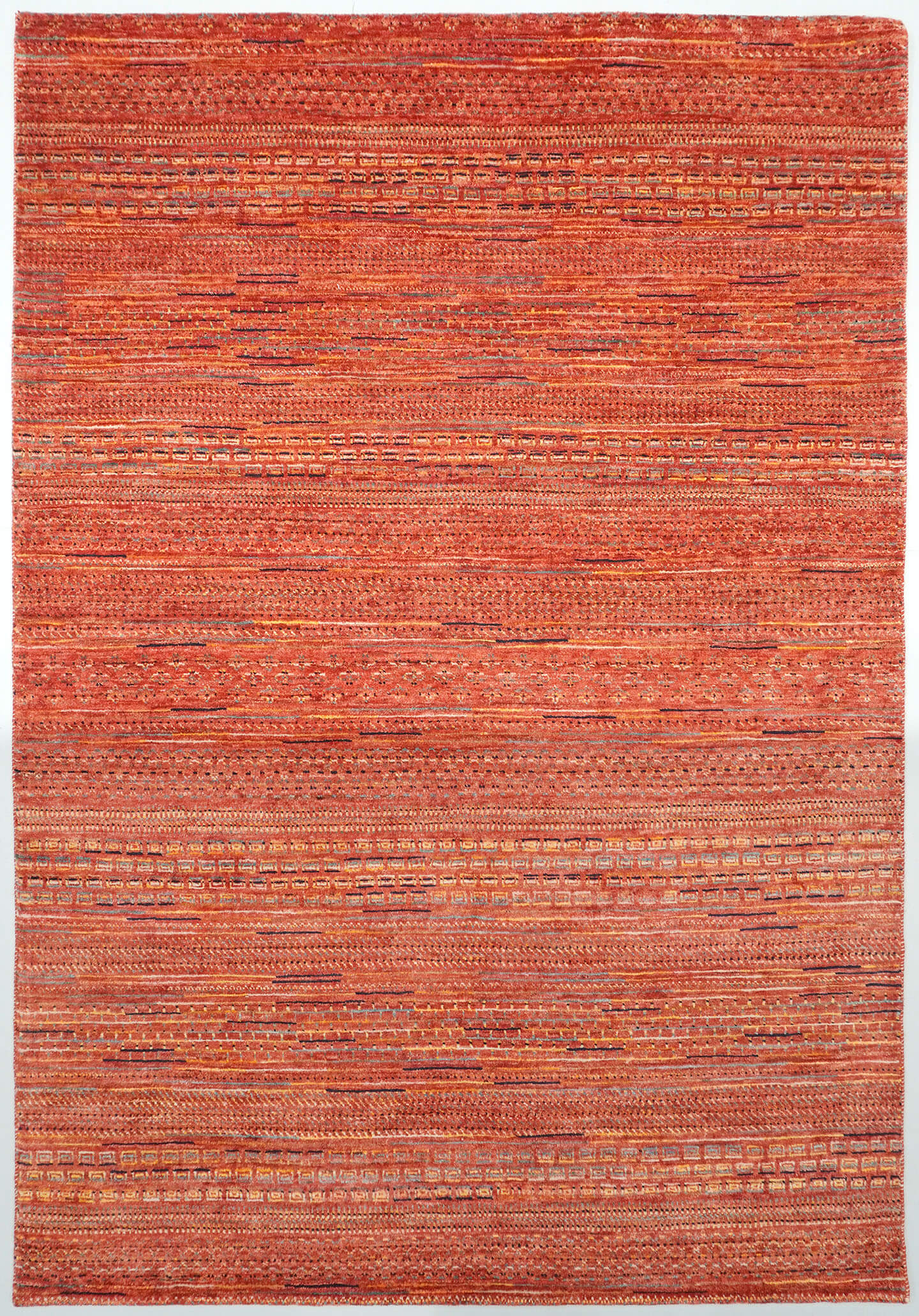 Full view of a sienna orange hand-knotted Aatish Gabbeh rug featuring rhythmic tiers of heritage Nakshe motifs.