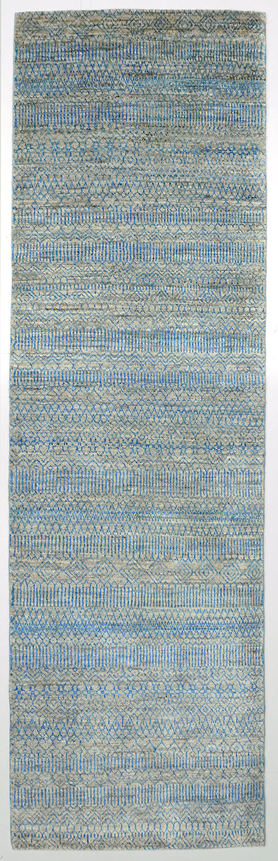 Full view of a silver grey hand-knotted Aatish rug featuring shifting, tie-and-dye blue Falak motifs.
