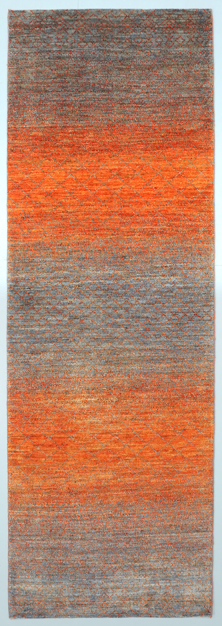 Full view of a slate grey hand-knotted Aatish rug featuring vibrating orange color transitions.