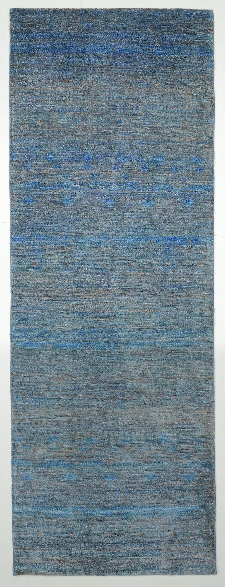 Full view of a slate grey hand-knotted Aatish rug featuring vibrating tie-and-dye blue Sarmad motifs