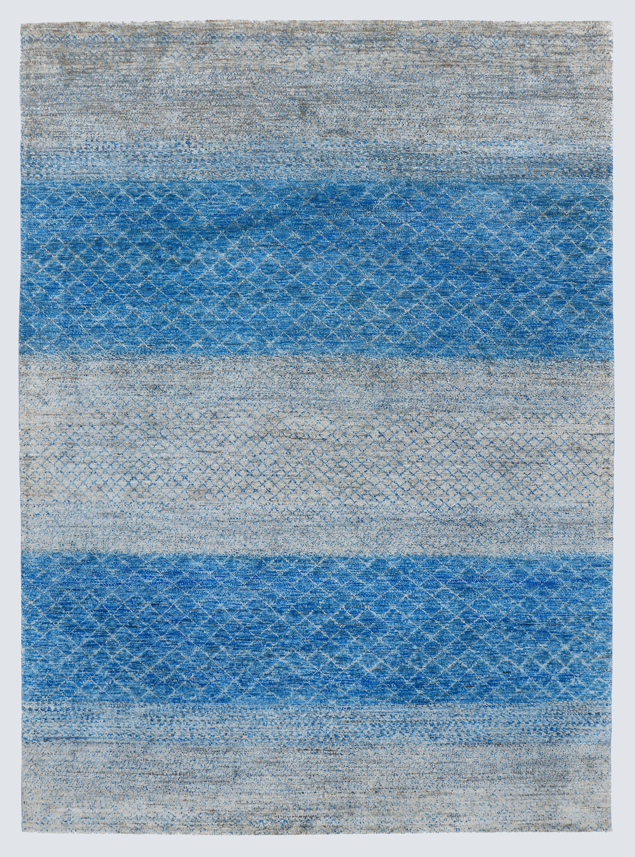 A full view of a large, high-density hand-knotted Aatish rug with horizontal bands of saturated blue over a multi-tonal silver-grey foundation.