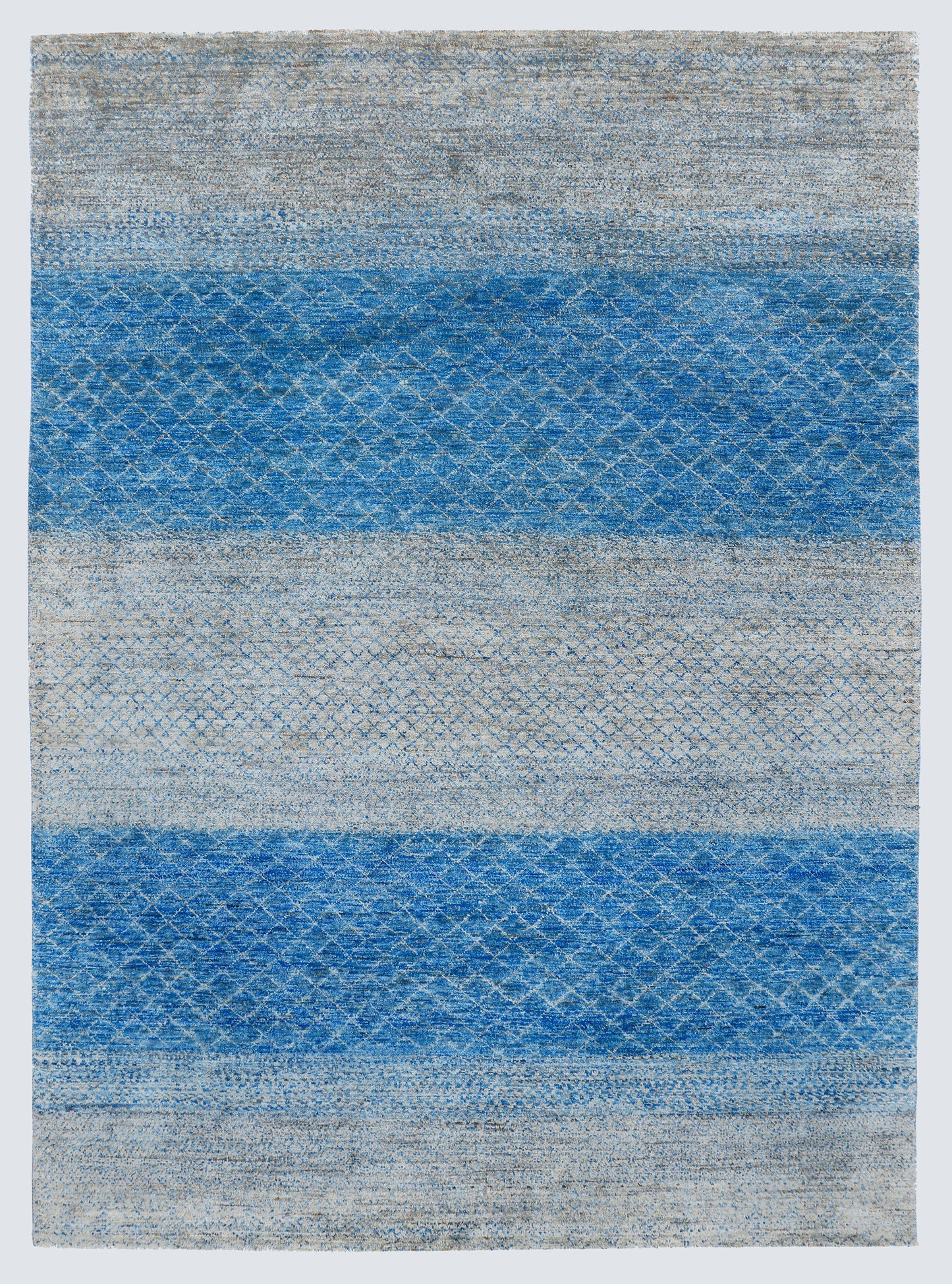 A full view of a large, high-density hand-knotted Aatish rug with horizontal bands of saturated blue over a multi-tonal silver-grey foundation.