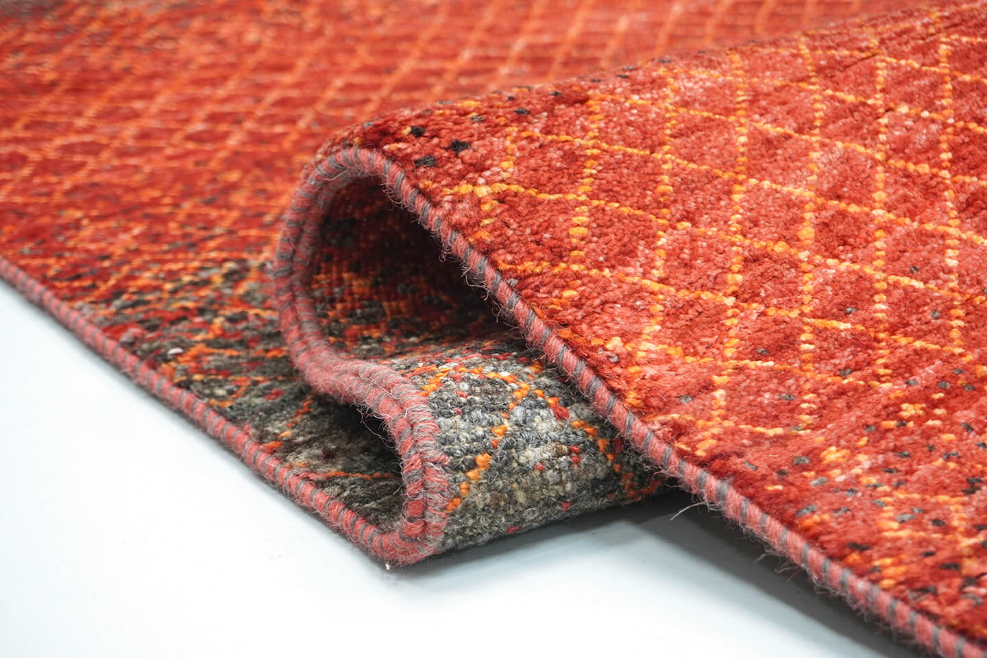 Close-up of the plush, natural brown wool pile and tie-and-dye orange levels of the Umber Mihrab rug